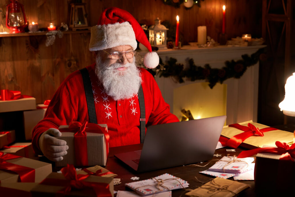 Weihnachtsmann sitzt vor dem Notebook